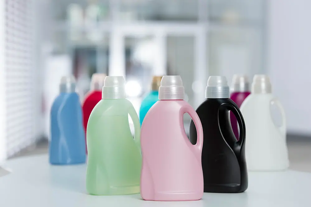 Prázdné plastové lahve Perwoll vyrobené z recyklovaného plastu