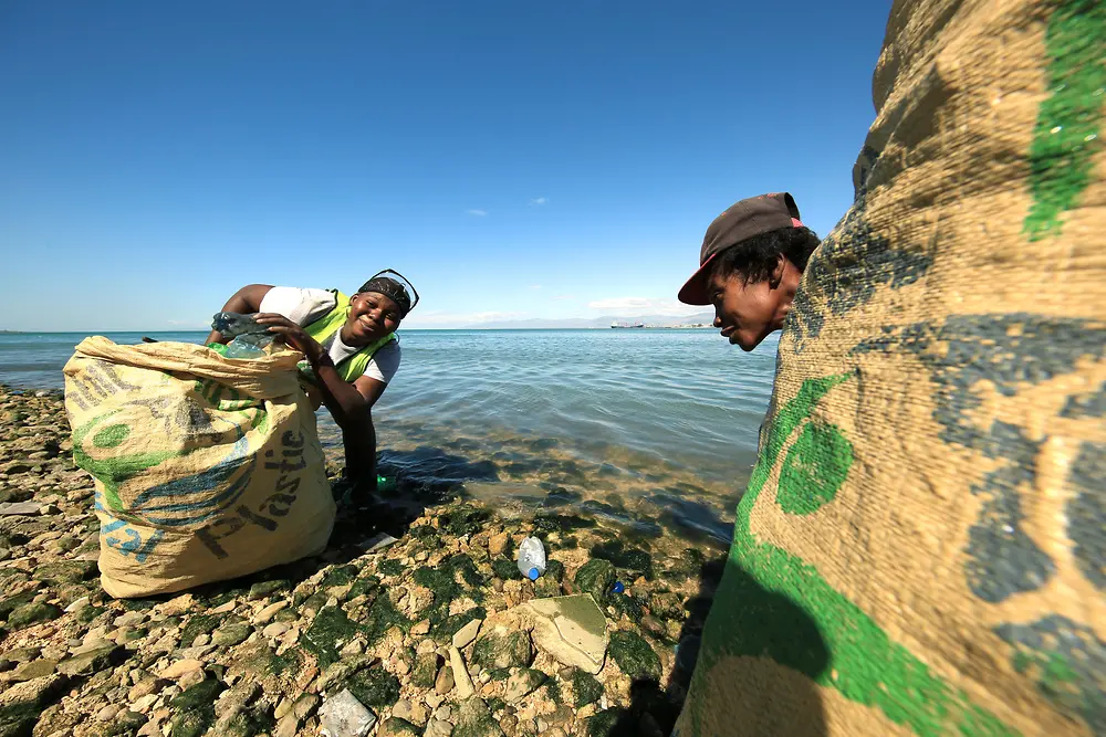 Projekt Plastic Bank: 2 osoby sbírající plasty na pláži