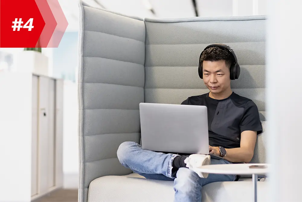 Zamestnanec spoločnosti Henkel Hao, vedúci Mobile App Factory, so slúchadlami na hlave a s laptopom