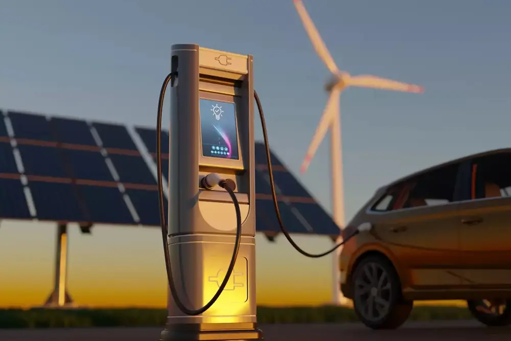 Nabíjecí stanice pro elektromobily se solárními panely a větrnými turbínami v pozadí.