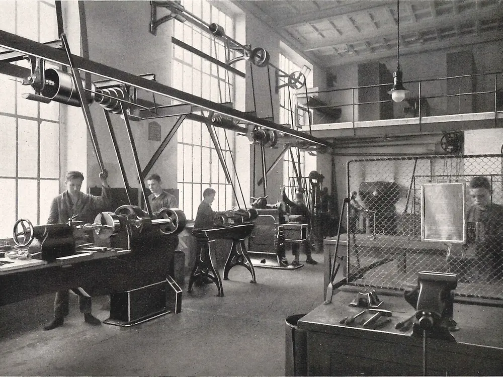 Učni pracující na strojích v kovodílně.