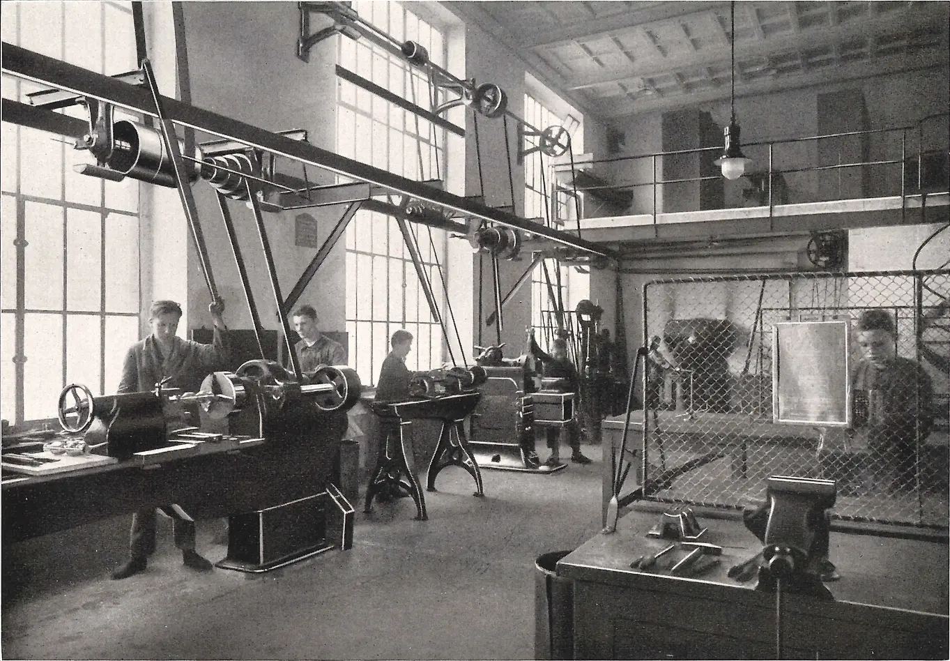 Učni pracující na strojích v kovodílně.