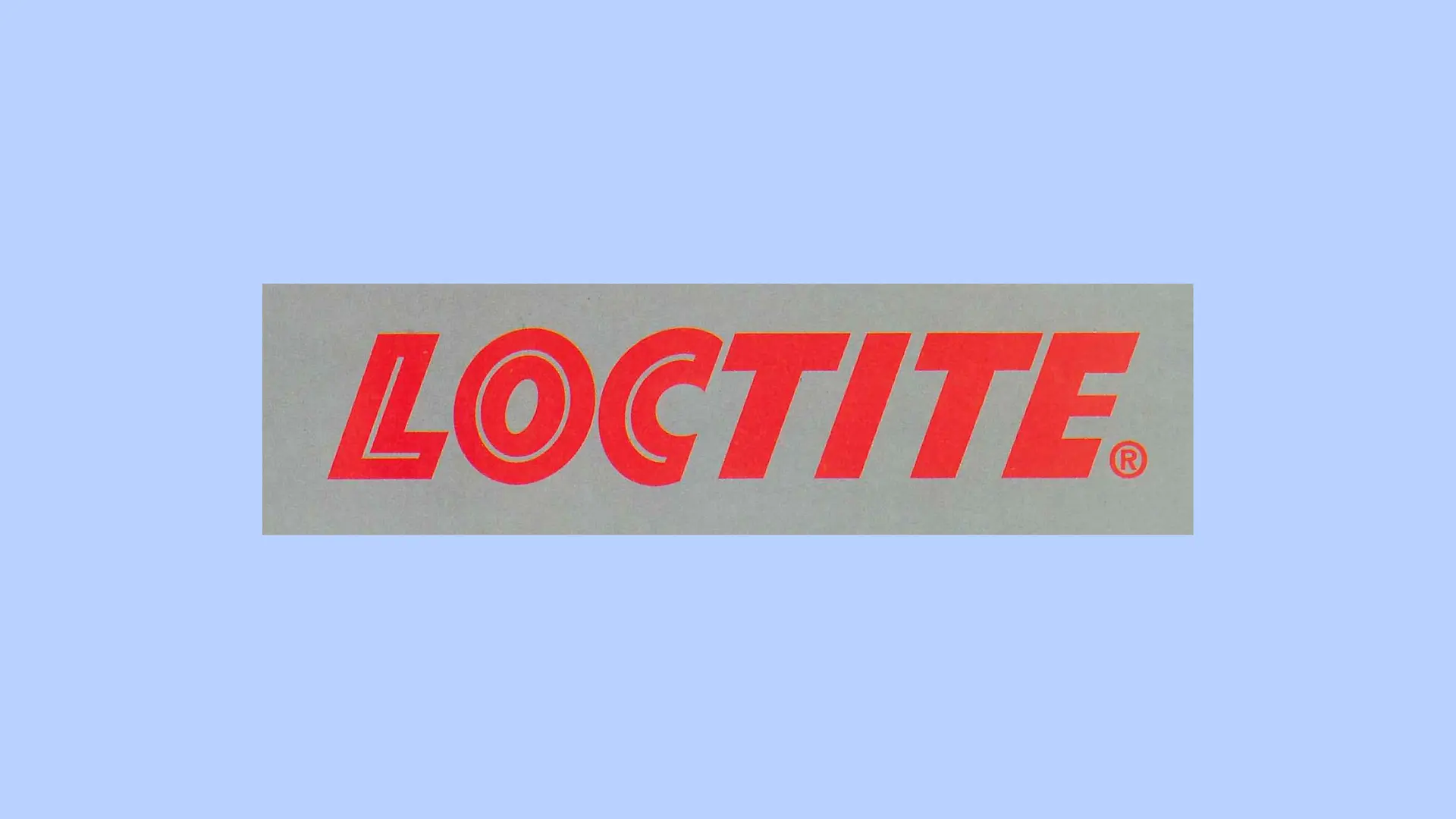 Červené logo Loctite na šedém pozadí.