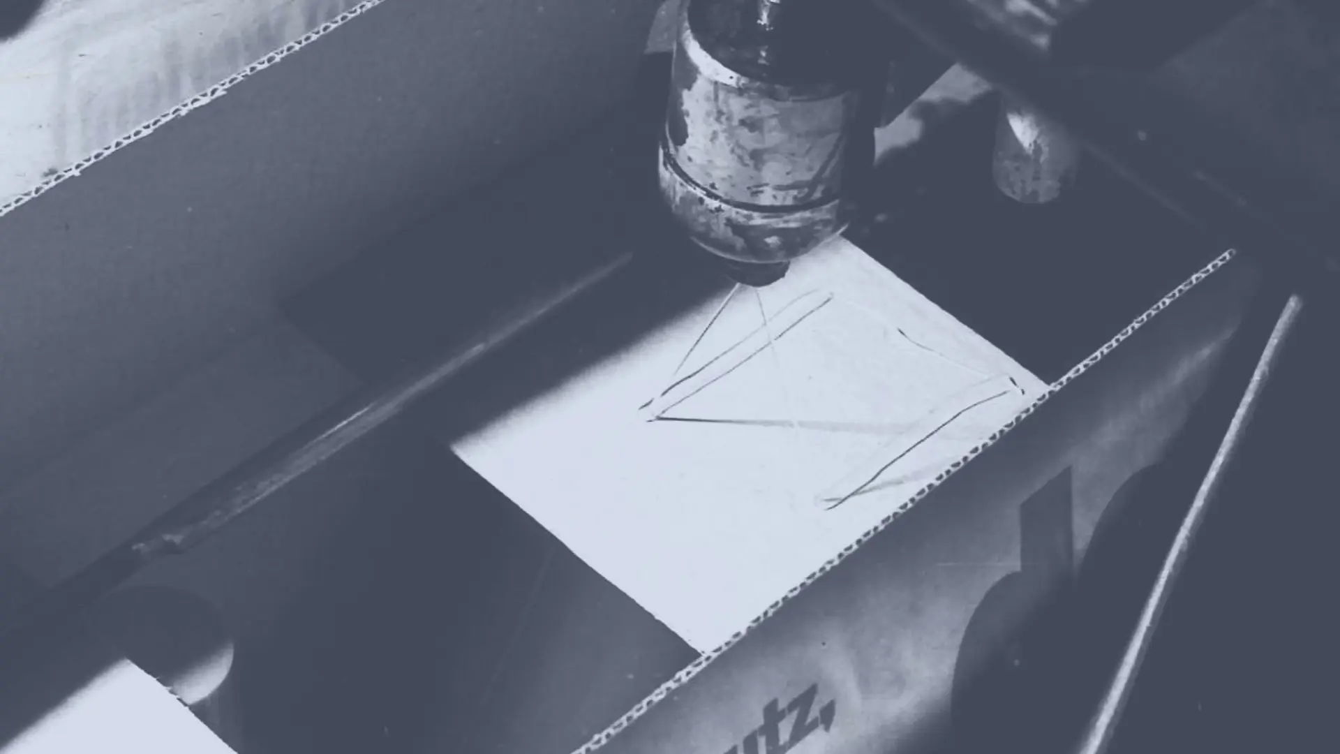 Horké lepidlo Technomelt je nanášeno na kartonovou krabici pomocí postřikové hlavy, aby ji zapečetilo.